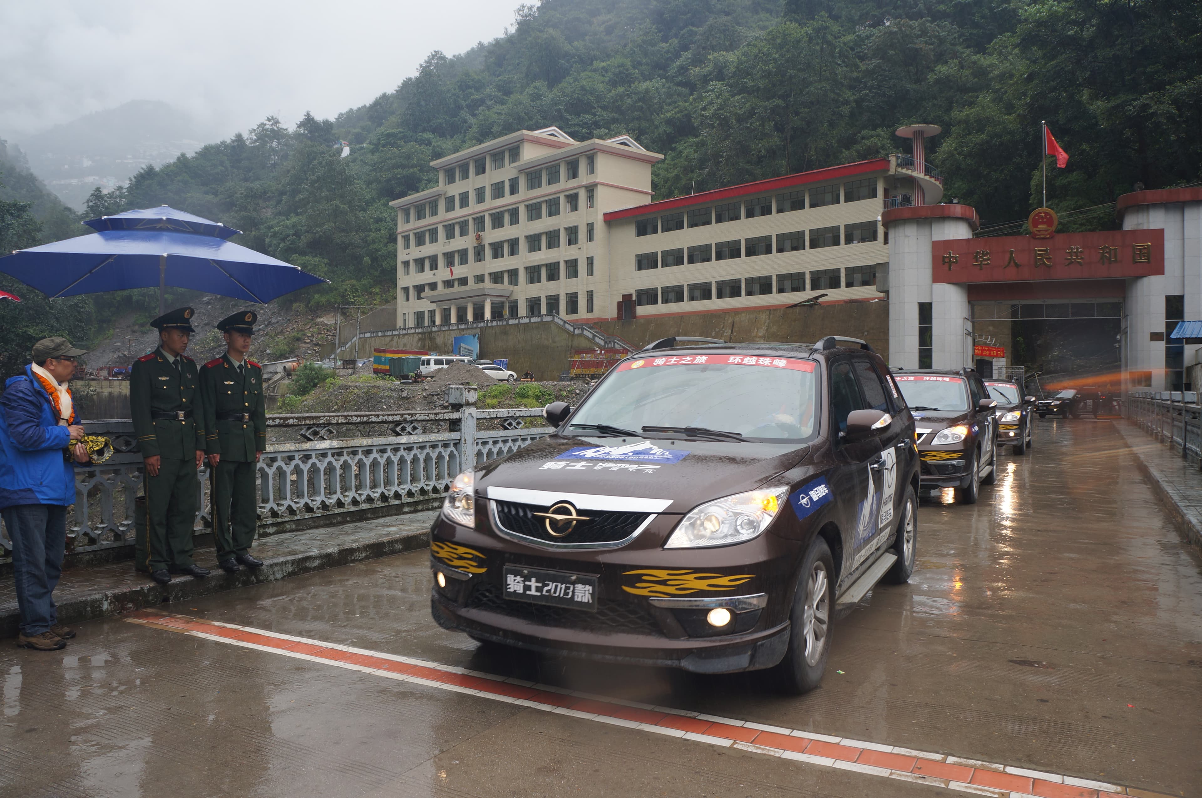 Tour convoy passing the Nepal-China border in rainy weather