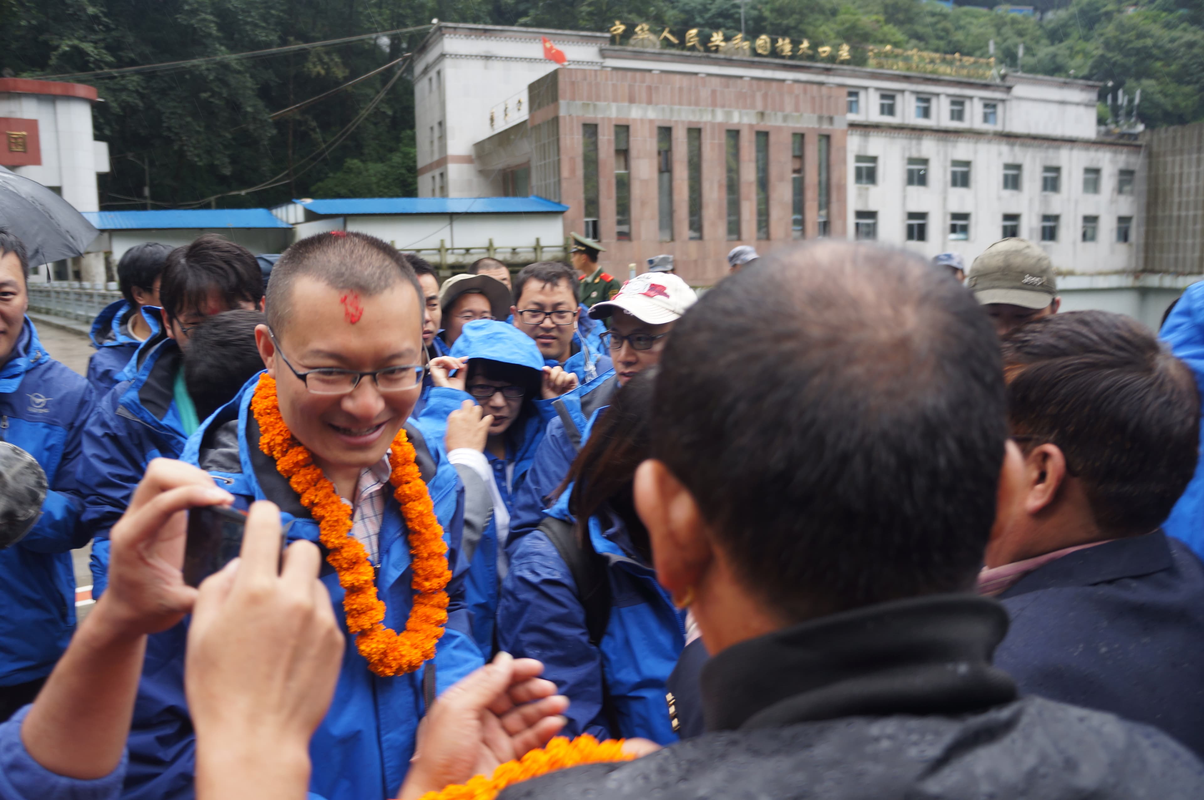 A visiting group gathered outside a building during a cultural welcome