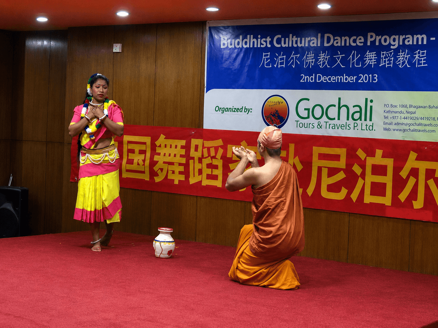 A dancer and Buddhist monk performing on stage during a Gochali cultural program