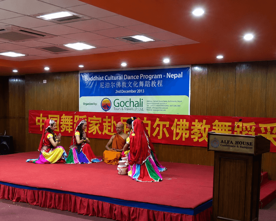 Dancers and a Buddhist monk performing during a cultural program in Nepal